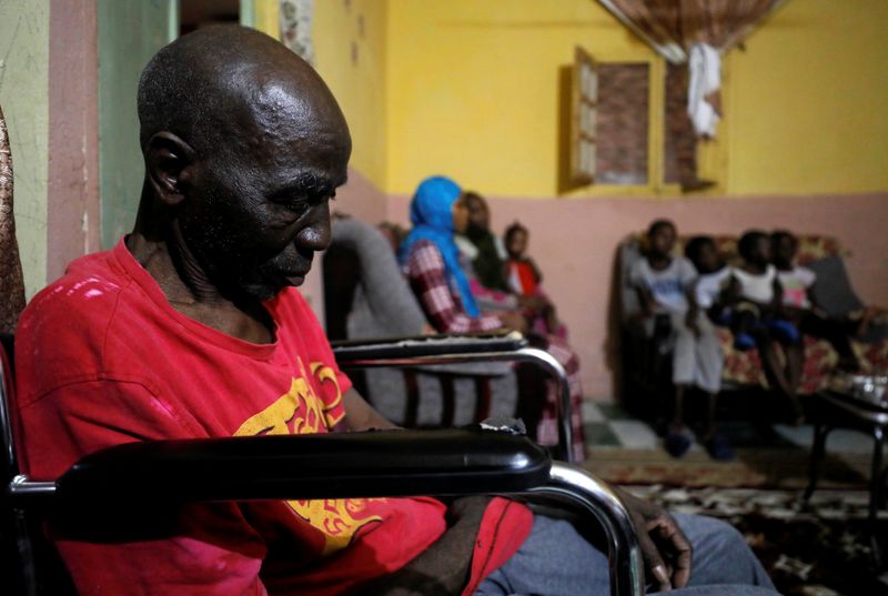 Sudanese refugee family sits in their living room in Ain