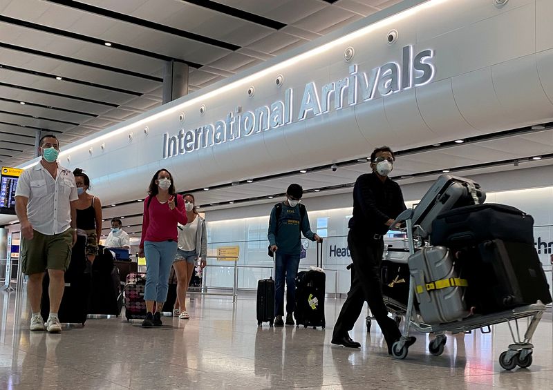 Passengers from international flights arrive at Heathrow Airport, following the