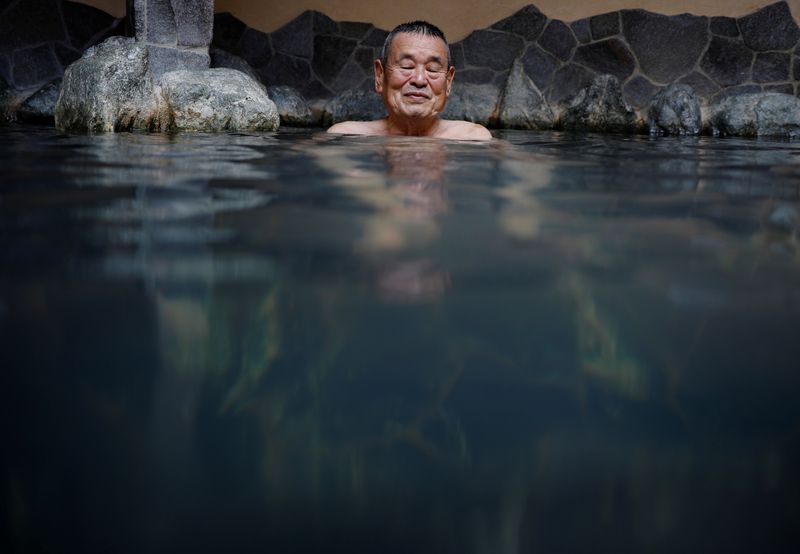 Customer soaks himself in a bath at public bathhouse in