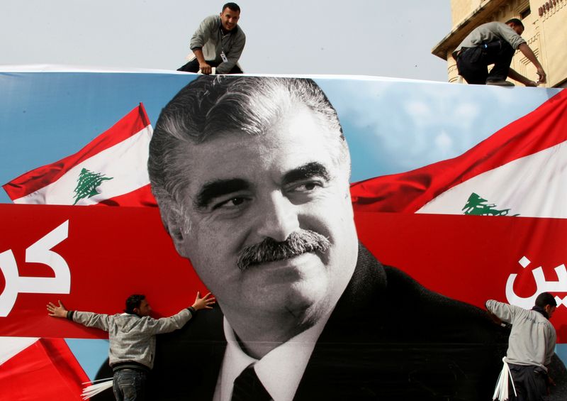 FILE PHOTO: Workers prepare a giant poster depicting Lebanon’s assassinated