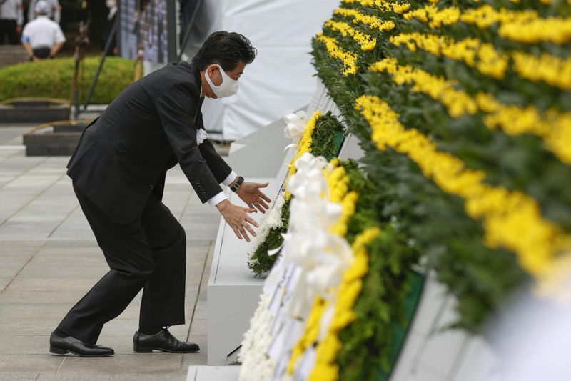 Japan’s Prime Minister Shinzo Abe offers a wreath to the
