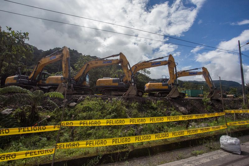 Excavators are parked near a damaged section of oil pipeline,