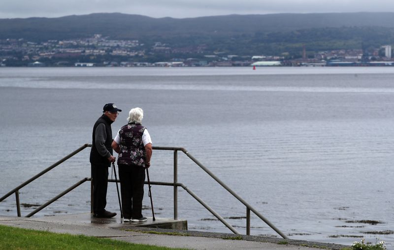 A couple look out to the Firth of Clyde near