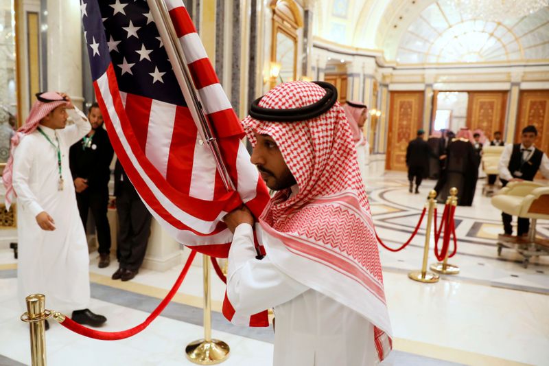 FILE PHOTO: A worker carries a U.S. flag into a