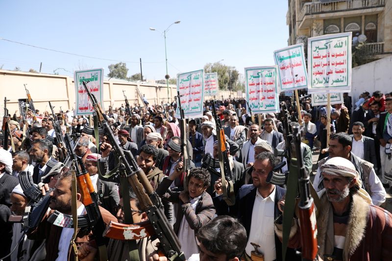 Houthi supporters hold up their weapons during a demonstration against