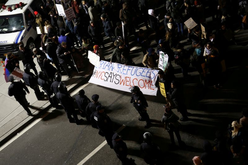 FILE PHOTO: Protesters gather with a sign that reads “Syrian