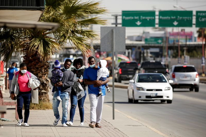 Migrants from Haiti walk near the Zaragoza-Ysleta international border bridge
