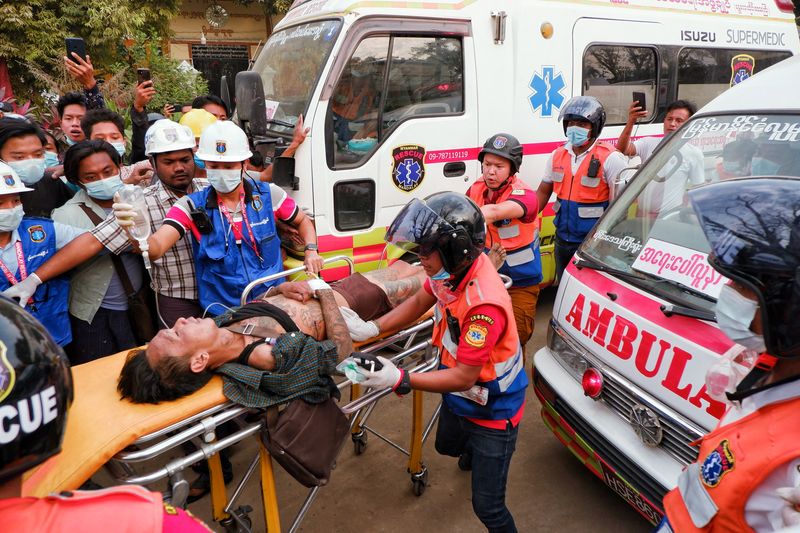 An injured man is carried by rescue workers after protests