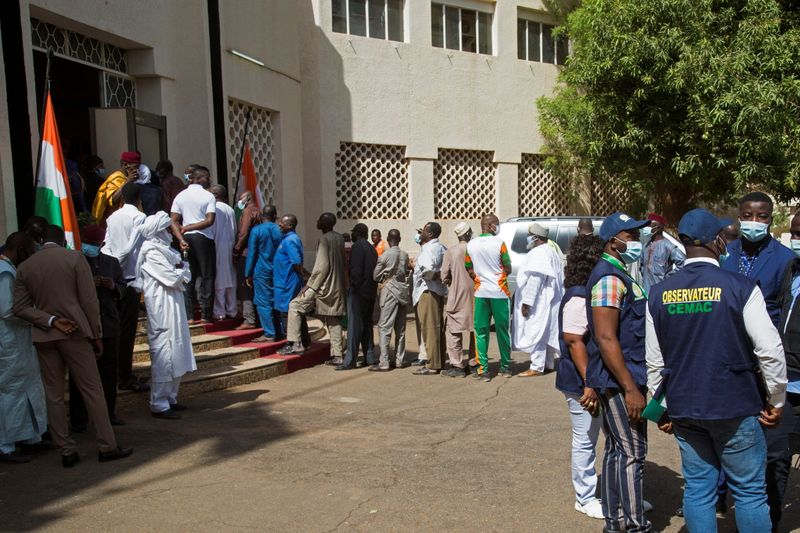 Voters queue at a polling station during the second round