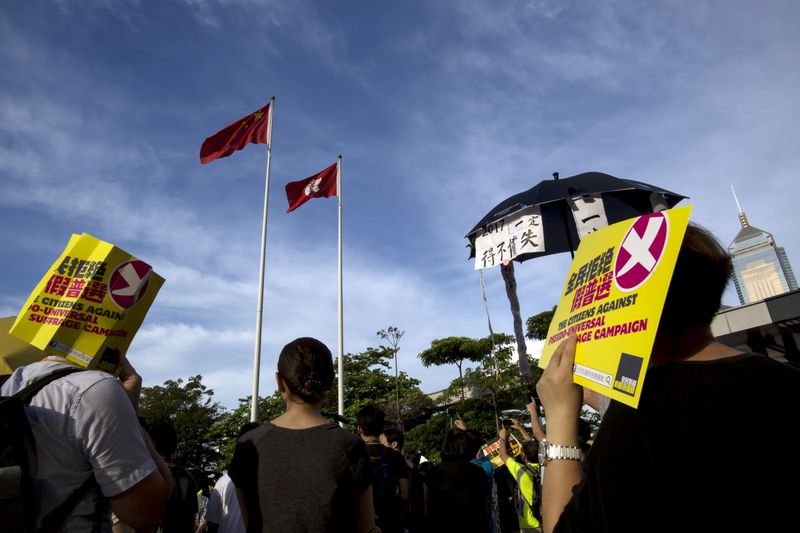 Pro-democracy protesters hold signs during a march under Hong Kong