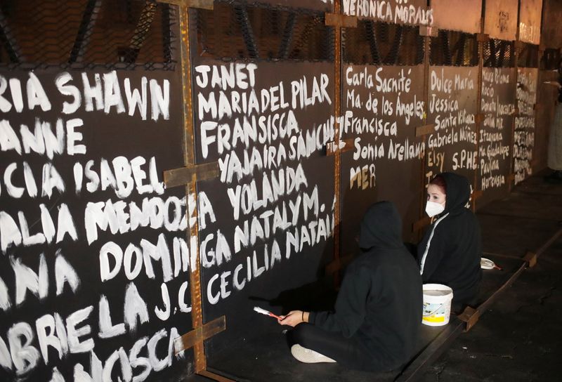 Women paint the names of victims of femicide in Mexico