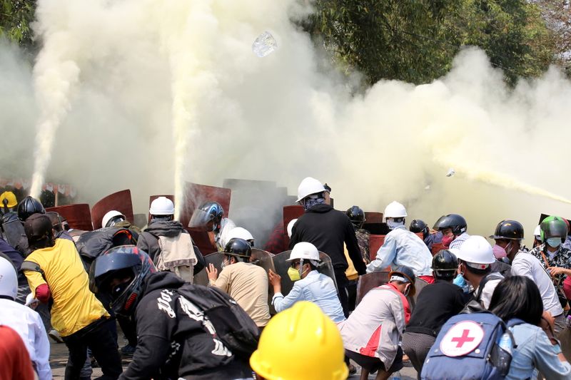 Tear gas and fire extinguisher gas float around demonstrators during