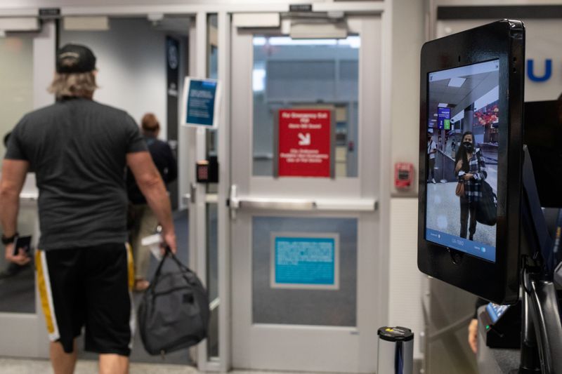 A passenger walks up to use biometric boarding at IAH