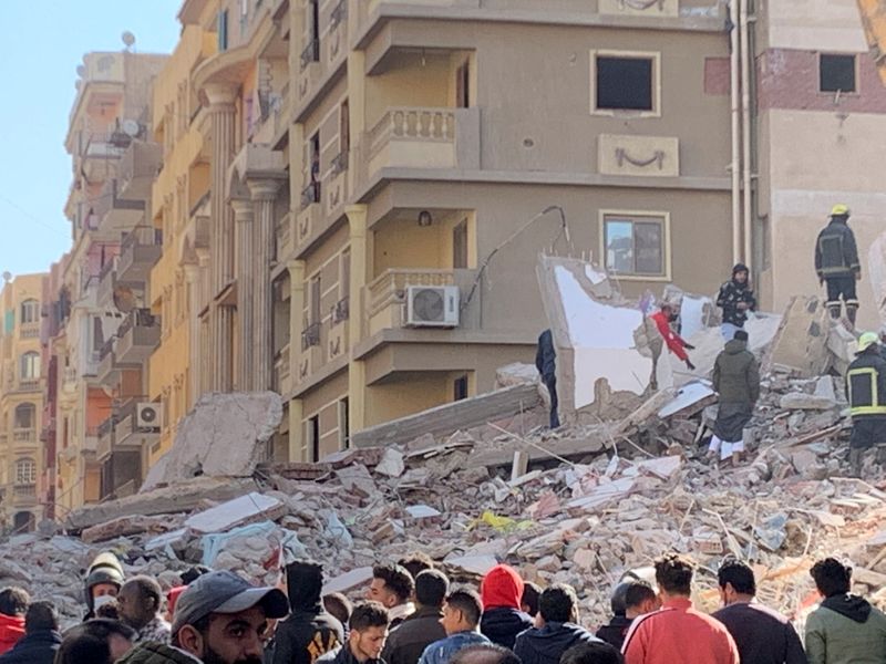 People inspect the area where a building was collapsed in