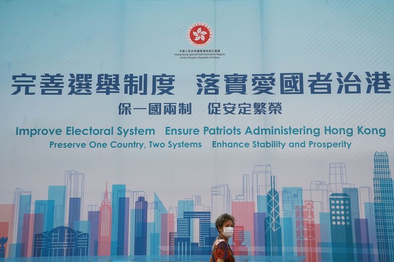Woman walks past a government advertisement promoting Hong Kong electoral