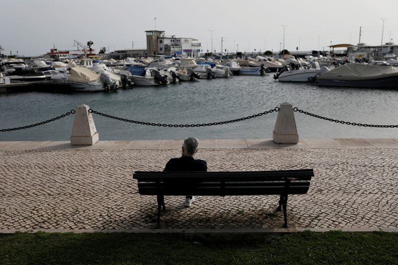 A man is seated in a bench at Faro marine,