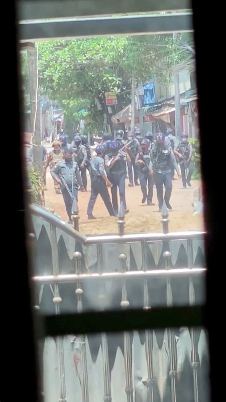 Security officers walk down the street during crackdown in Bago