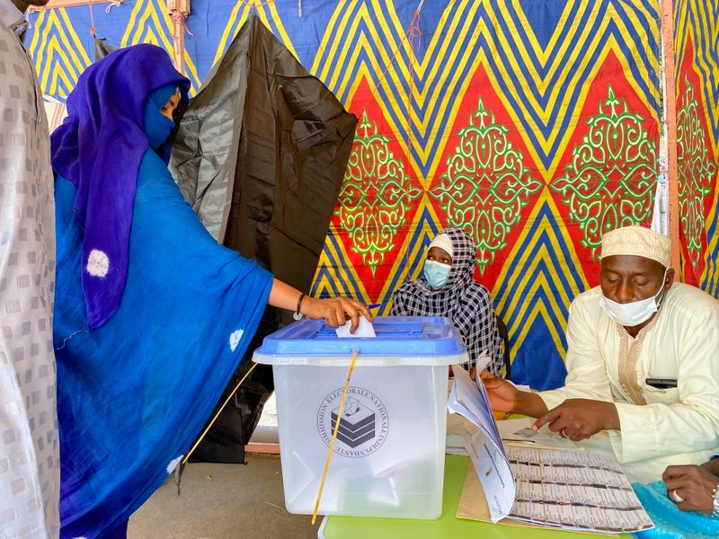 A woman casts her ballot at the pooling station during