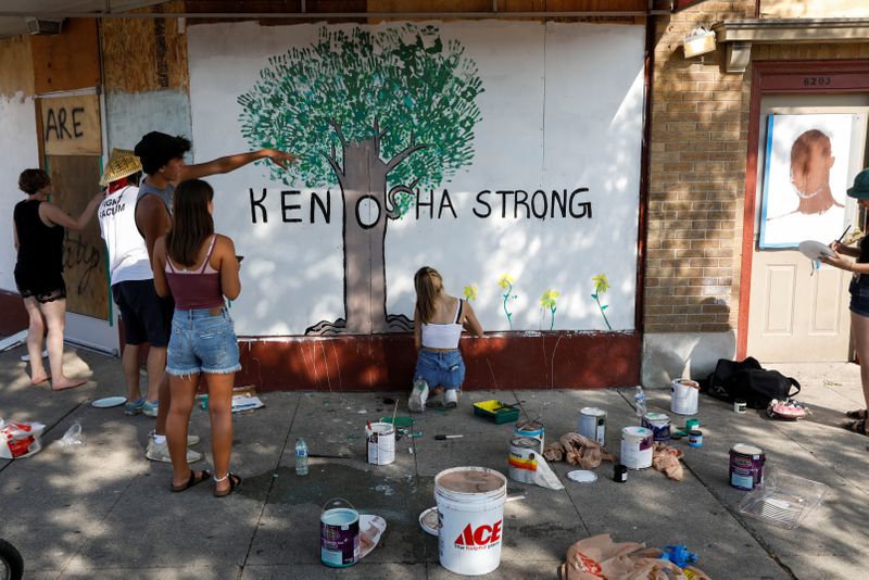 People paint a mural following the police shooting of Jacob