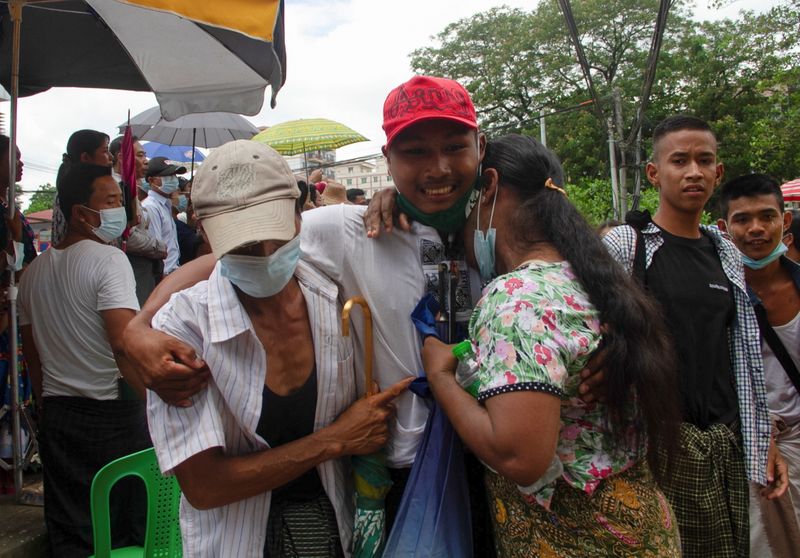 A released prisoner reacts with his relatives outside the Insein