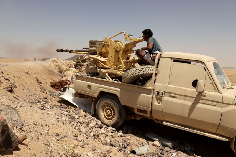 FILE PHOTO: Yemeni government fighter fires a vehicle-mounted weapon at