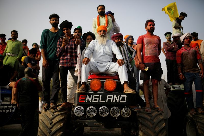 FILE PHOTO: Farmers watch Nihangs, or Sikh warriors, perform near