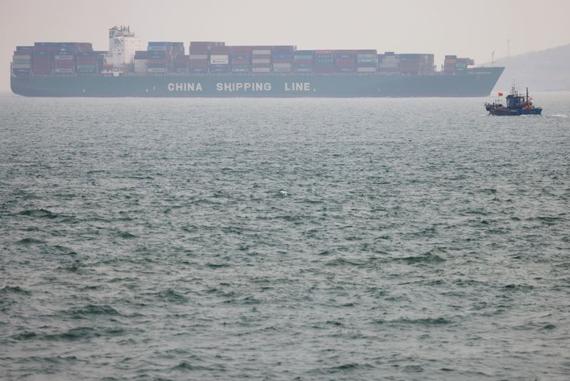 Fishing boat is seen near a China Shipping Container Lines
