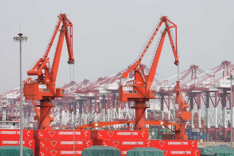 Canadian Tire containers are seen near cranes at Qingdao port