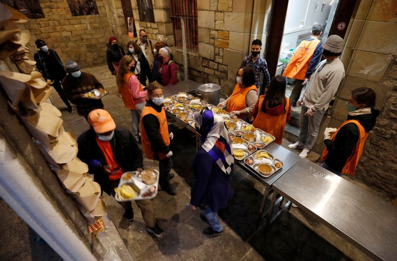 People carry food trays during a charity Ramadan dinner in