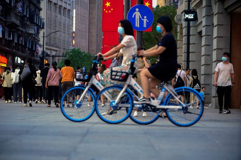 Người phụ nữ đi xe đạp trên đường phố, sau khi bùng phát dịch bệnh coronavirus (COVID-19), ở Thượng Hải