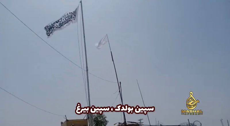 An Islamic Emirate of Afghanistan flag flutters in front of