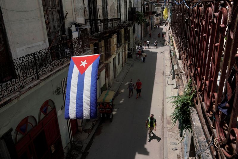 A Cuban flag hangs over a street in Havana