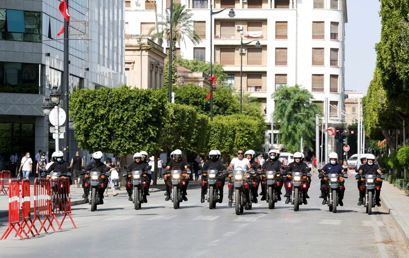 Police officers patrol a street in Tunis