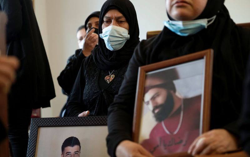 Relatives of victims of Beirut port explosion, hold their pictures