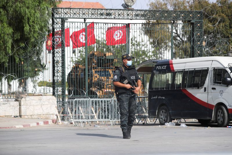 Police officers stand guard outside the parliament building in Tunis