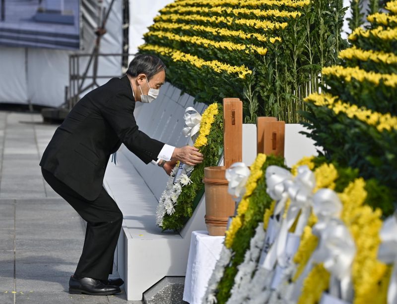 Japan’s Prime Minister Yoshihide Suga places a wreath on the