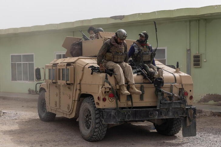 Members of Afghan Special Forces climb down from a humvee