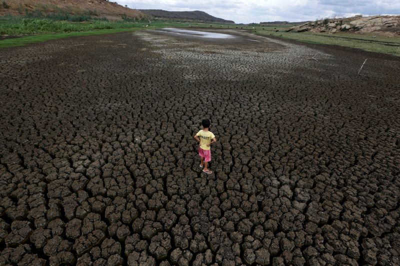 FILE PHOTO: A boy stands on the cracked ground of