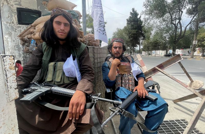 FILE PHOTO: Members of Taliban forces sit at a checkpost