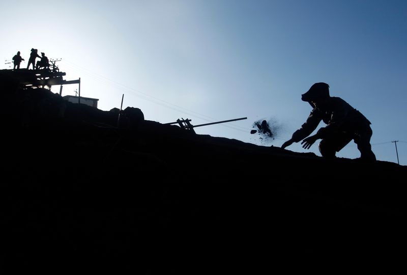 FILE PHOTO: Afghan miner sifts through coals at Karkar coal