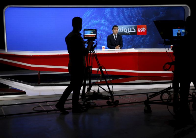 FILE PHOTO: Cameraman films a news anchor at Tolo News