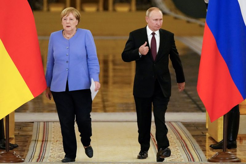 Russian President Putin and German Chancellor Merkel attend a news