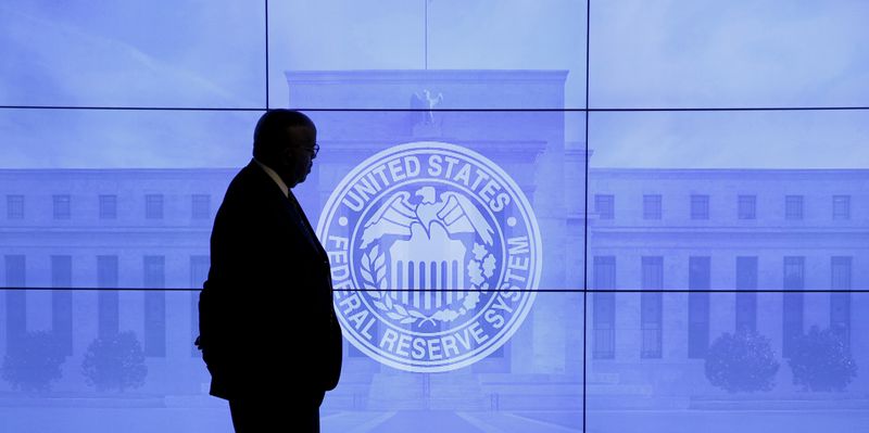 A guard walks in front of a Federal Reserve image