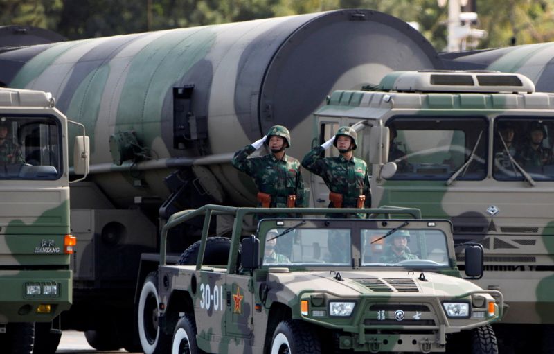 FILE PHOTO: PLA soldiers salute in front of nuclear-capable missiles