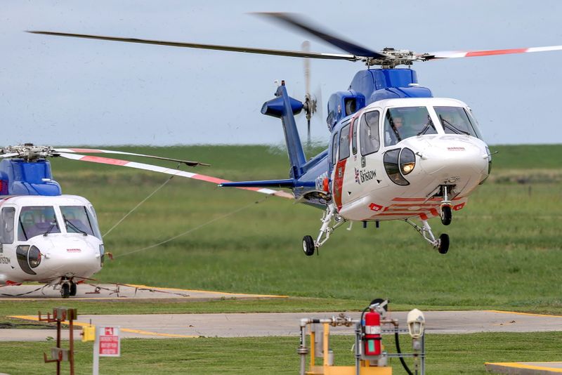 FILE PHOTO: A helicopter carrying evacuated workers from oil production