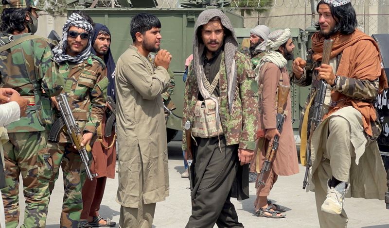 FILE PHOTO: Taliban forces patrol at a runway a day