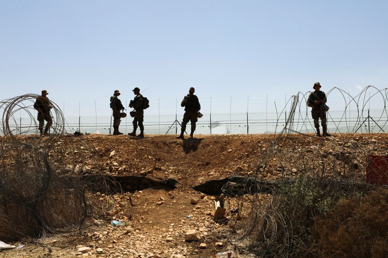 Israeli soldiers guard along a fence leading to the Israeli-occupied