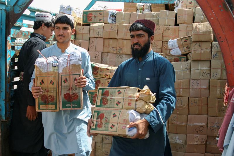 FILE PHOTO: Labourers unload boxes of pomegranates from Afghanistan, from
