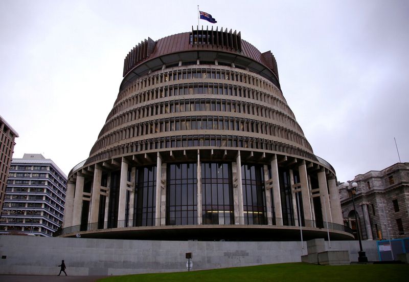 A pedestrian walks past the New Zealand parliament building known