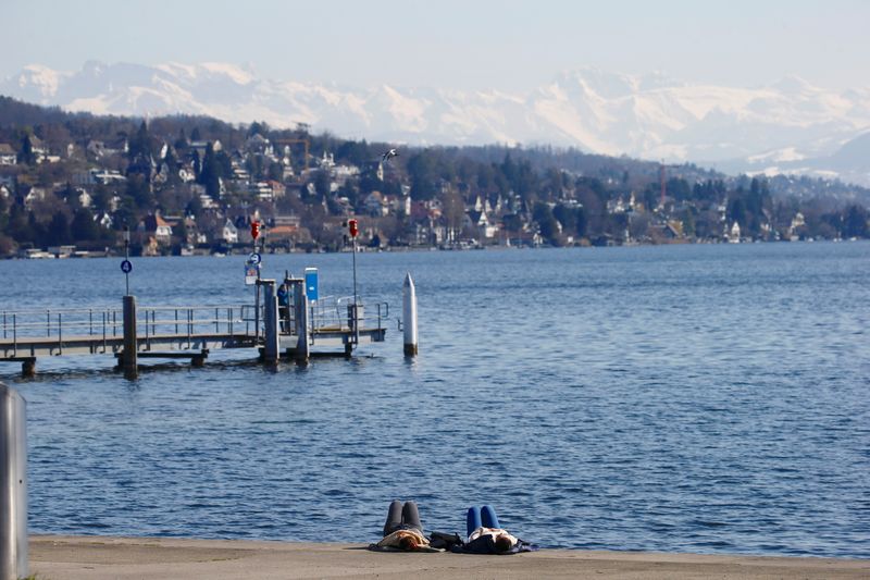 FILE PHOTO: Women relax on the banks of Lake Zurich